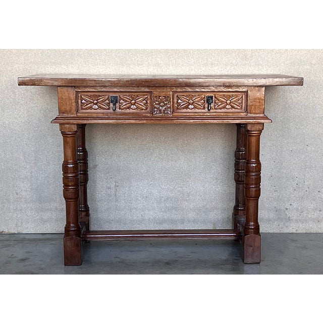 Early 20th century carved Spanish console with two drawers. This table with character is of rare narrow depth. It is...