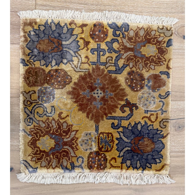 Hand-knotted wool rug fragment featuring an all-over floral and botanical design with stylized blossoms and scrolling vine...