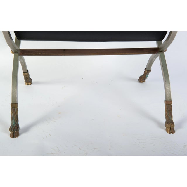 Steel and leather Maison Jansen style magazine stand with exquisitely detailed brass cloven hoof feet and ball finials.