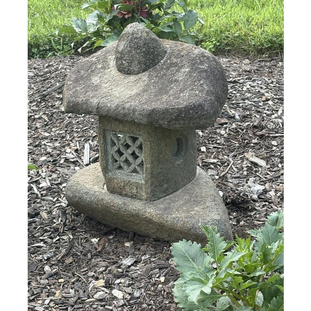 A beautifully weathered, hand-carved granite garden lantern in the Japanese Yukimi gata (“snow viewing”) style, with its...