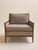 A clean-lined mid century lounge chair with a walnut frame and tailored beige upholstery. The broad seat, angled arms, and...