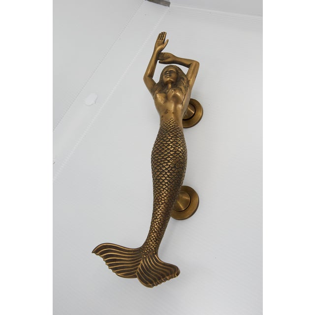 Stunning solid brass mermaid door handle fixture, standing at approximately 13" tall. Features a substantial build and...