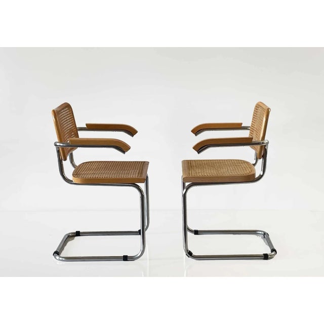 Pair of vintage armchairs with chrome structure, caned seats and backrests, wooden armrests.