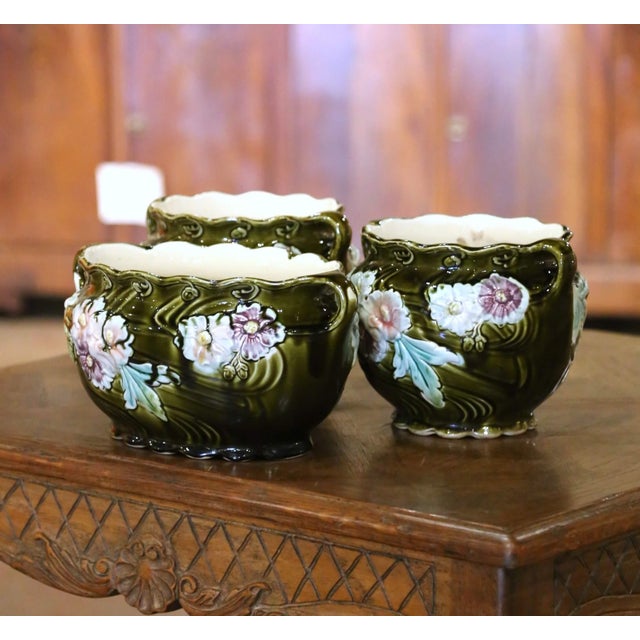 Colorful and highly sculptural, this antique three-piece barbotine garniture reflects the naturalistic elegance of the...