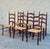 French Provincial dining chairs with shaped ladderback frames, handwoven rush seats, and turned finial posts. Solid wood...