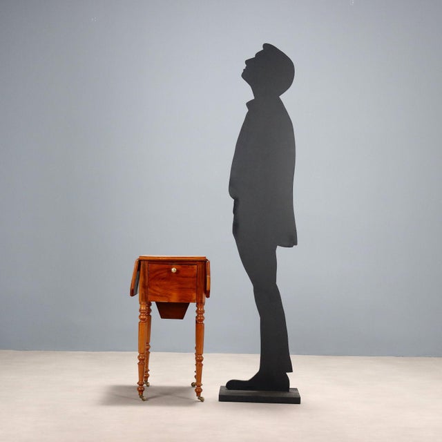 Mahogany hinged table, pair of drawers under the top on one side, drop-leaf door on the other. Turned octagonal legs,...