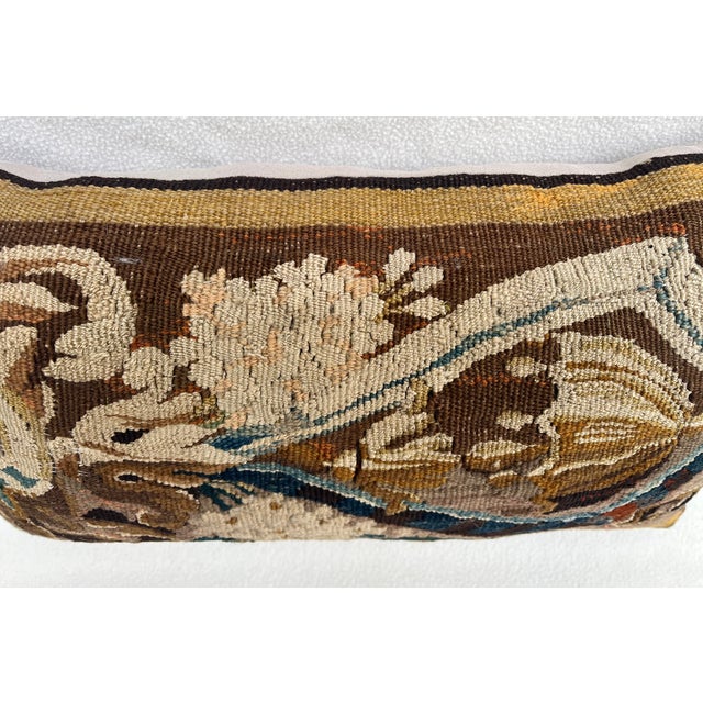 A charming decorative pillow crafted from an exquisite 18th-century tapestry featuring a striking pattern of large,...