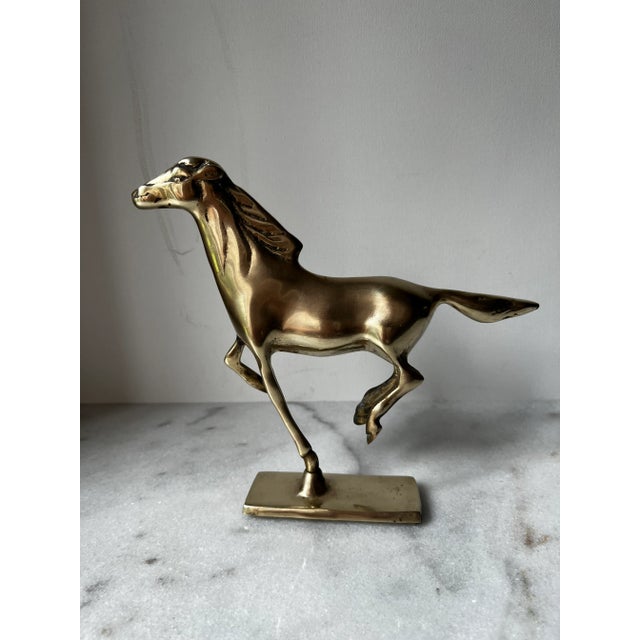 This vintage solid brass running horse figurine in gold color is a collectible piece originating from India. Crafted from...