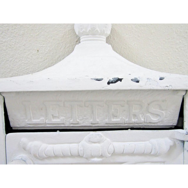The Victorian Wall Mounted Cast Iron Painted White Mailbox is a medium-sized mailbox made of durable cast iron in a...