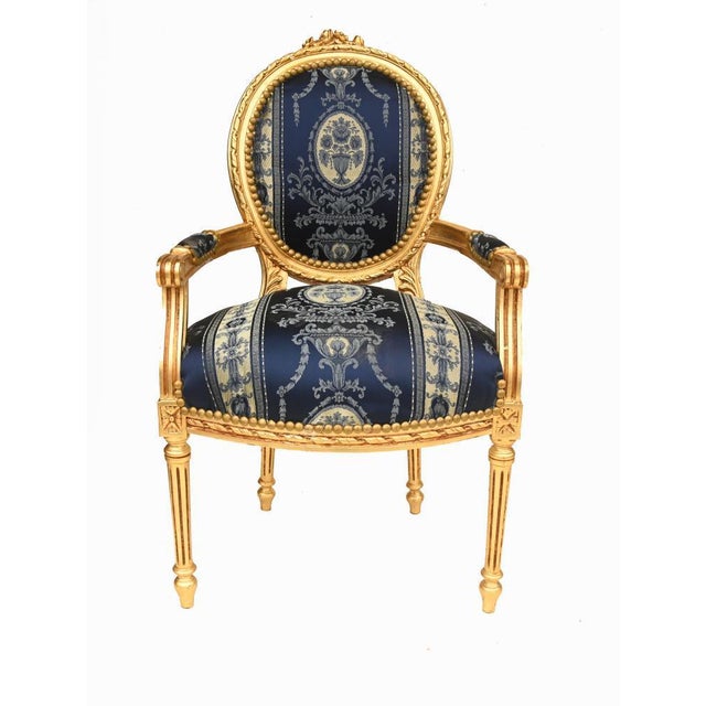 Elegant pair of French Louis XVI style giltwood armchairs with beautifully carved frames and oval backs The carved...
