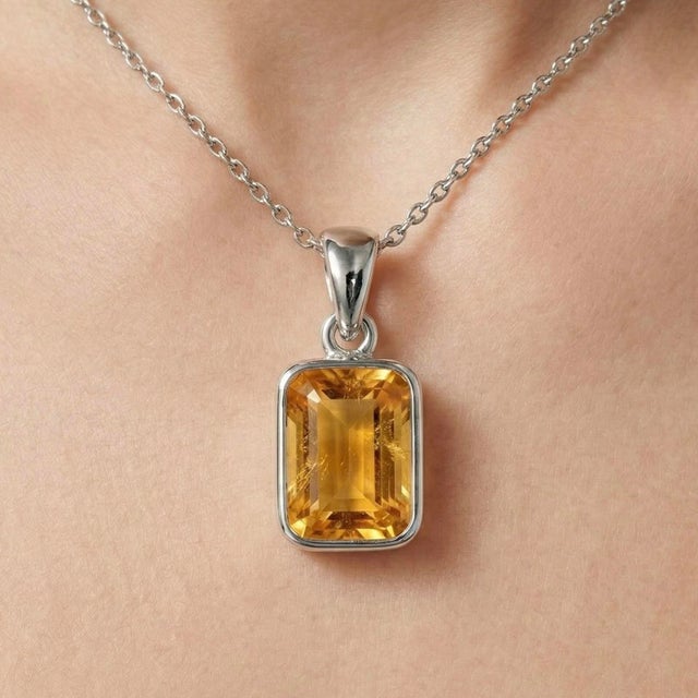 This elegant pendant features a radiant Citrine gemstone, admired for its warm golden hue and vibrant brilliance. Often...