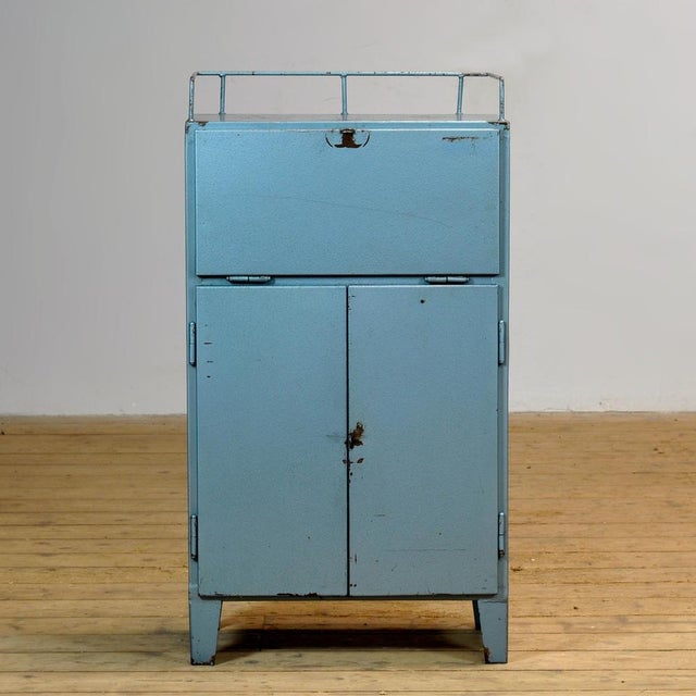 Bring a touch of vintage industry to your interior with this robust 1970s cabinet. Made of iron and finished in a blue hue...