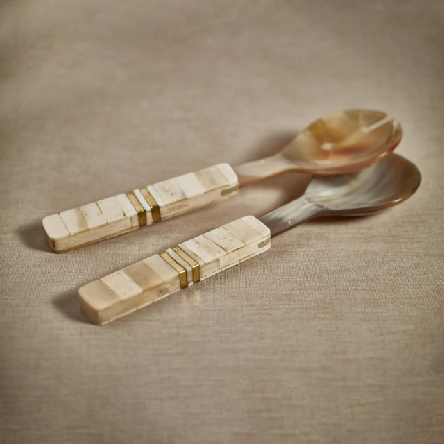Beautifully crafted horn salad servers, each utensil features a simple shape with a finish that accentuates the horn's...