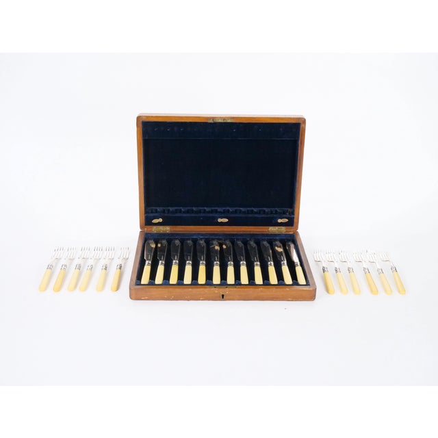 An elegant English fish cutlery service comprising 24 pieces, including 12 fish knives and 12 matching forks, crafted in...