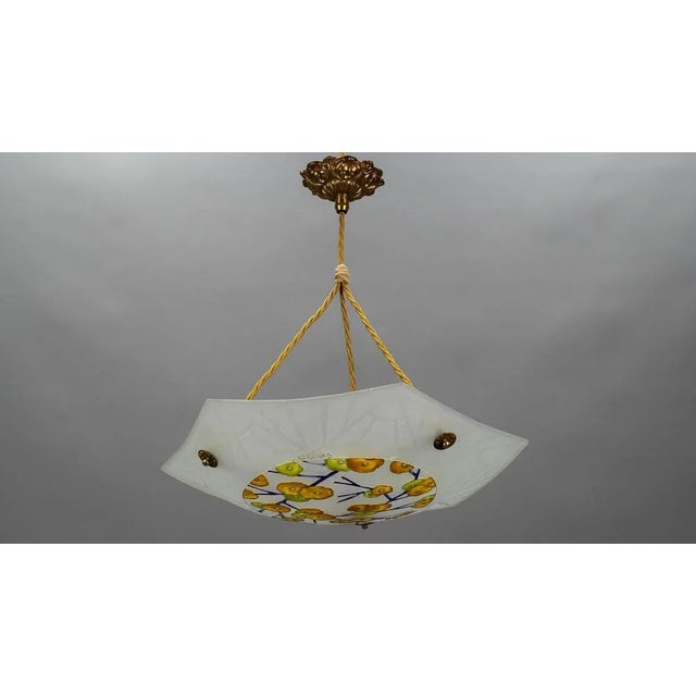 This beautiful art deco molded, frosted, and enamel painted glass ceiling light features a floral design in yellow,...