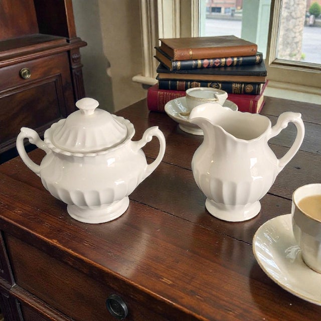 This Vintage English Ironstone J & G Meakin Classic White Sugar Bowl and Creamer Set is a timeless piece of porcelain...