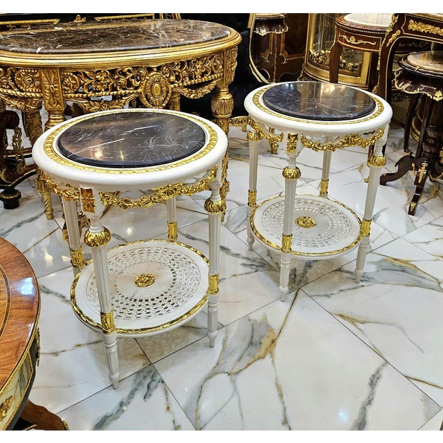 Elegant French-style side table featuring a luxurious black marble top framed with a delicate gold-leaf border. The table...
