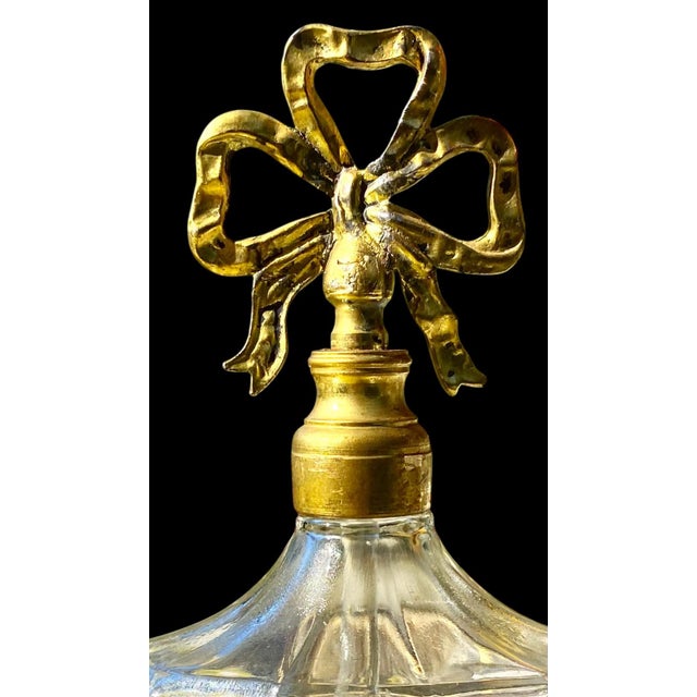 A vintage 1950’s ormolu and glass perfume bottle, featuring ornate gilt-Metal filigree mountings in styles popular during...