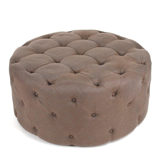 The Round Tufted Ottoman from Zentique in aubergine linen adds a rich, jewel-toned accent to living rooms and bedrooms....