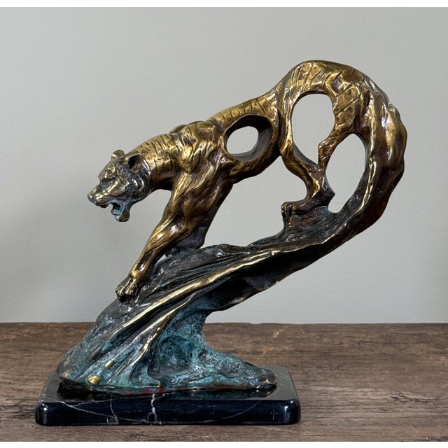Sculptural bronze tiger in a dynamic leaping pose, executed in an Art Deco style with strong musculature, openwork body,...