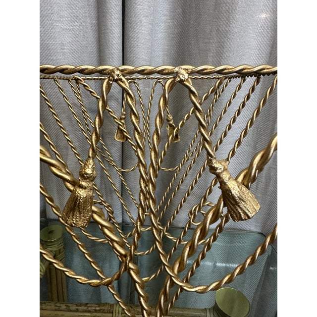 Vintage wrought iron gilt magazine rack with metal tassel detail.