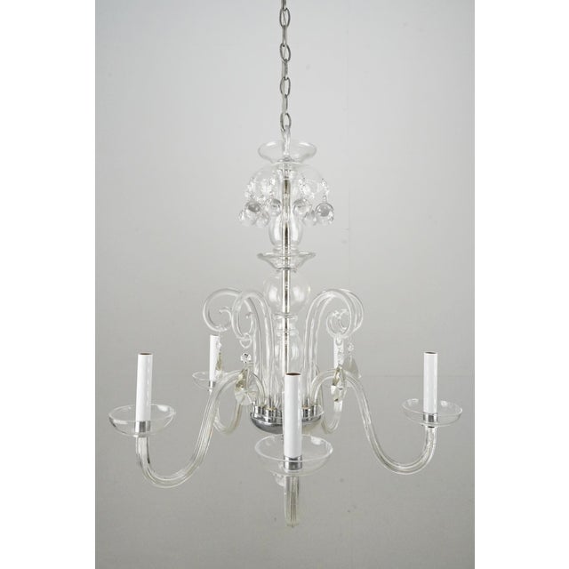 Traditional style chandelier made of clear crystal with a brushed steel frame and chain. This light requires five E-12...