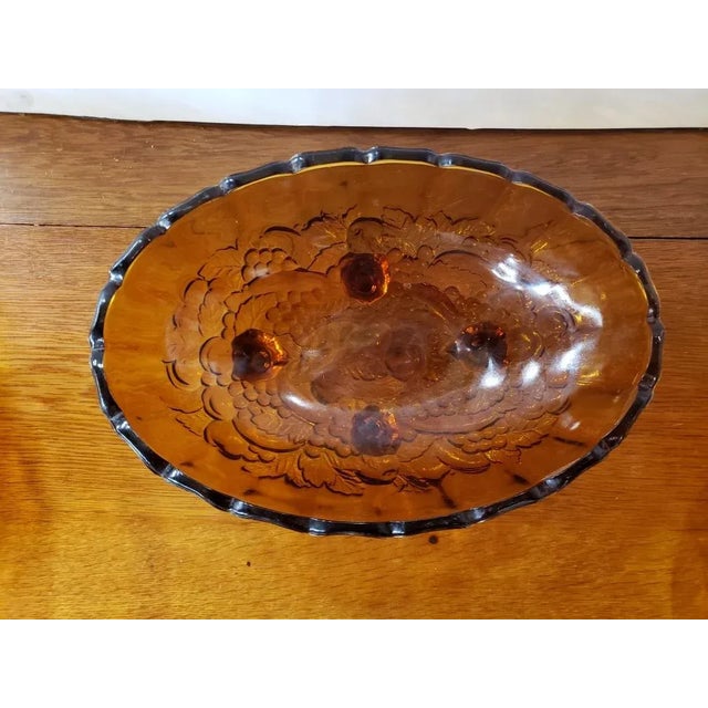 This is a Vintage Indiana Amber Glass Grapes and Leaves Motif Oval Footed Serving Bowl. It measures 4 1/2" high, 12 1/2"...