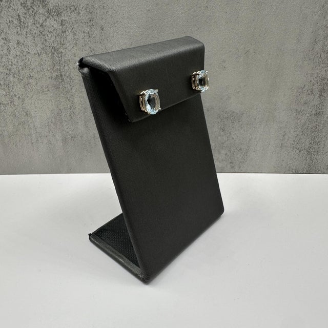 These elegant aquamarine stud earrings in 14kt yellow gold feature 3.21 carats total weight of oval cut aquamarines set in...