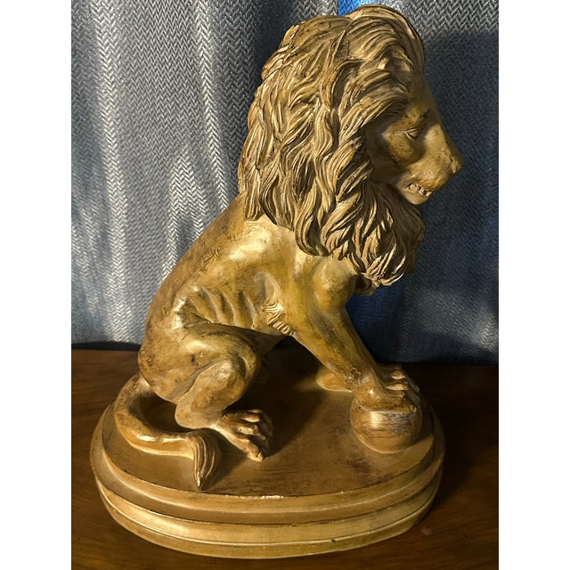 A striking vintage classical-style lion sculpture, crafted in resin with a warm antiqued gold gilt finish. This regal lion...