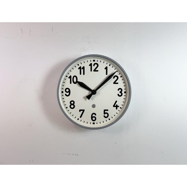 This wall clock was produced by Chronotechna in former Czechoslovakia during the 1950s. It features a grey metal frame, an...