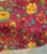 Genuine Designers Guild "Kasuti" printed cotton — a bold, richly saturated floral on a deep red ground, with marigolds,...