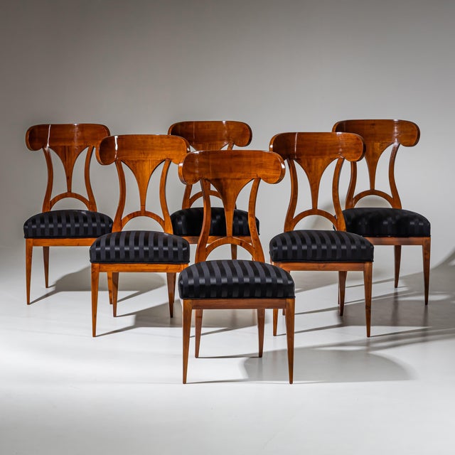 Set of six Biedermeier side chairs with high backrests terminating in characteristic shovel-shaped tops. The chairs stand...