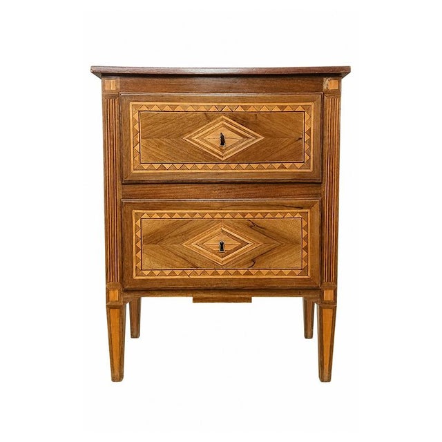 An elegant two-drawer bedside table crafted from fine woods with refined geometric inlays that enhance every surface. The...