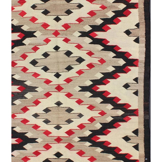 This intriguing antique Navajo rug was woven in the United States during the first half of the 20th century. The exciting...