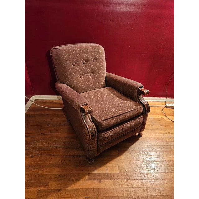 Antique/vintage upholstered armchair with carved wooden arms. Neutral mauve color.