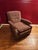 Antique/vintage upholstered armchair with carved wooden arms. Neutral mauve color.
