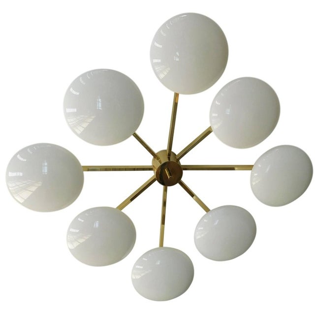 Italian flush mount with eight glossy white Murano glass shades mounted on solid brass frame in lacquered polished brass...