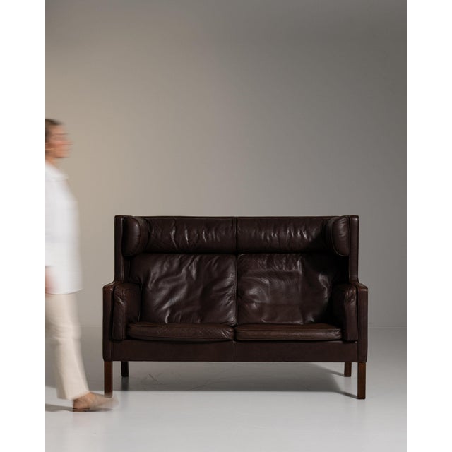 Two-seat leather sofa in Deep Espresso Brown. Its deep espresso brown finish sets off rolled arms, espresso leather...