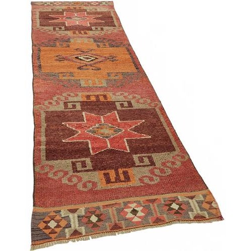 This exquisite runner rug is a rare example of tribal craftsmanship, hand-knotted by the women of the Herki tribe during...