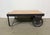 Former pallet truck from a factory now serves as a coffee table. It features a black iron construction with two original...