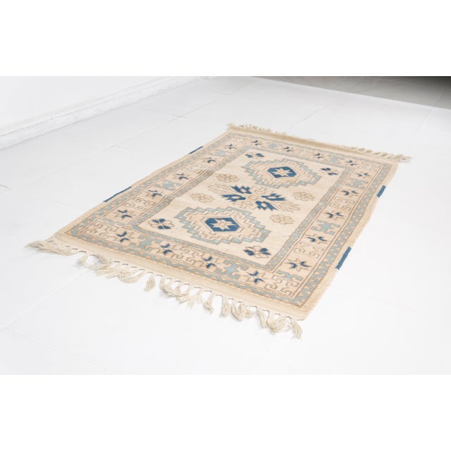 This is a vintage Turkish Oushak rug from the Mid 20th Century. The piece was hand-knotted.