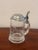 This elegant vintage German beer stein features a clear glass body with an etched Equestrian Horse motif, topped with a...