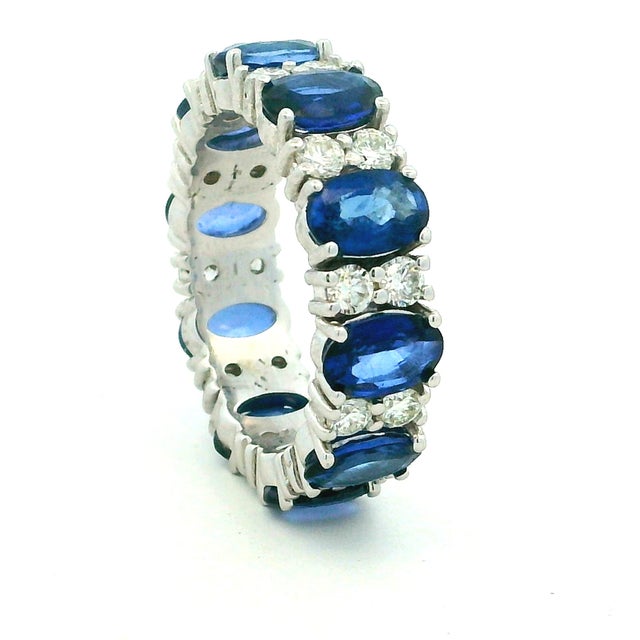 A richly colored sapphire and diamond eternity band crafted in 18K white gold. Ten oval-cut blue sapphires from Thailand,...