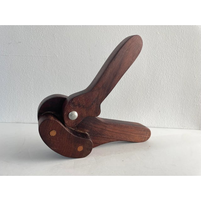 A handcrafted solid walnut wood nutcracker crafted with soft curves. This piece is sculptural and functional.