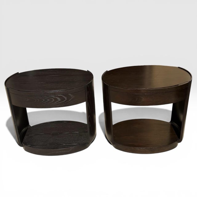 A beautiful pair of bedside tables designed by Barbara Barry for McGuire. Oval tables with slight raised galleries each...