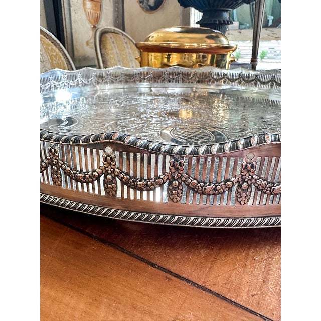 The border of this tray is short wall with drapery detailing. The center of the tray is an intricately etched floral design.