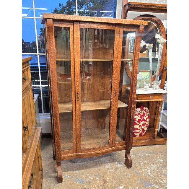 Antique Tiger oak china/display cabinet. Empire style. Beautiful clean lines. The bowed glass door adds to the charm of...