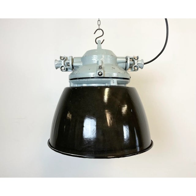 Grey industrial light with massive protective glass bulb. Cast aluminium body, clear glass. Black enameled shade with...