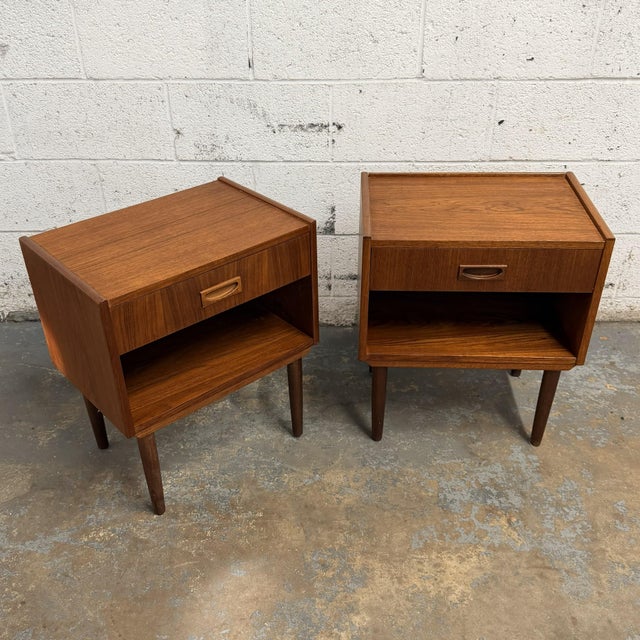 This complimentary pair of Danish teak nightstands has a great box-form design, with single drawers over open cubby...