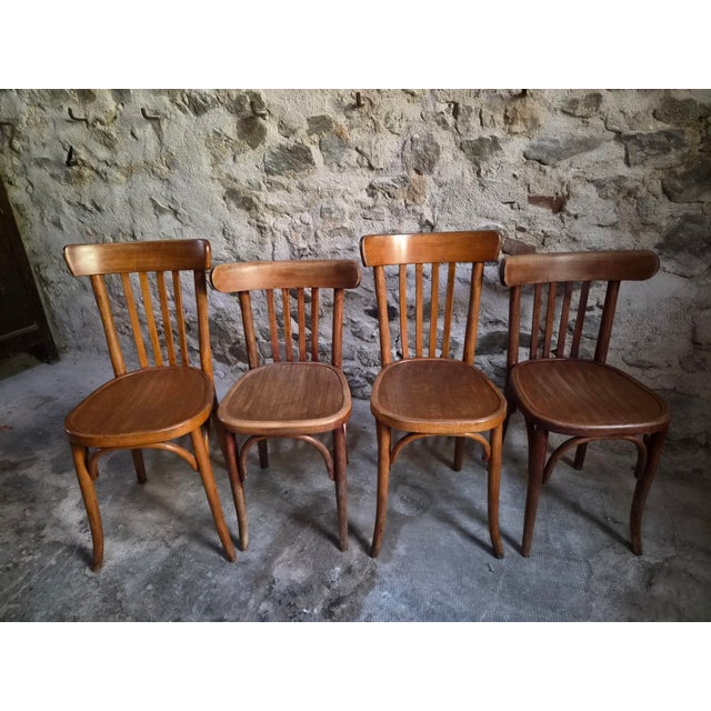 A set of four antique French bistro chairs dating from the 1930s, consisting of two different but complementary models by...